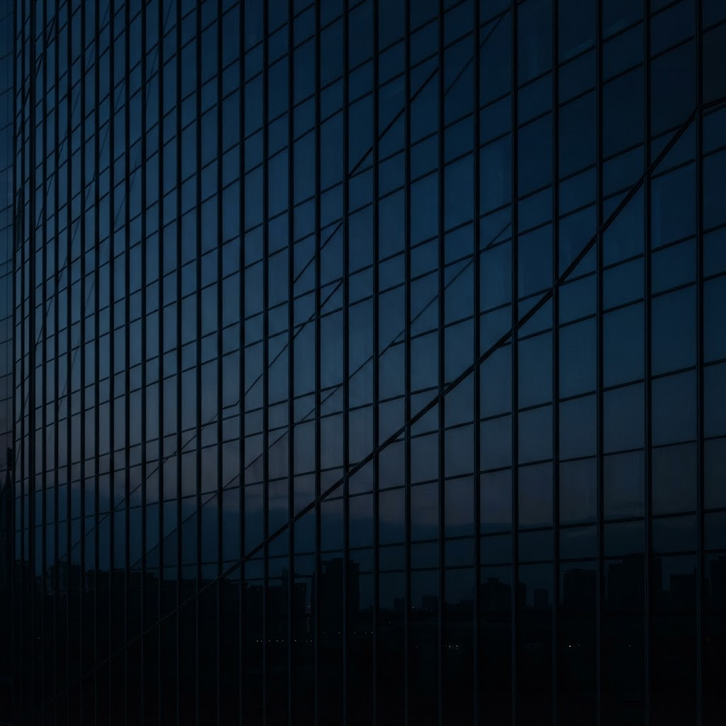Dark glass curtain wall facade reflecting the dusk sky